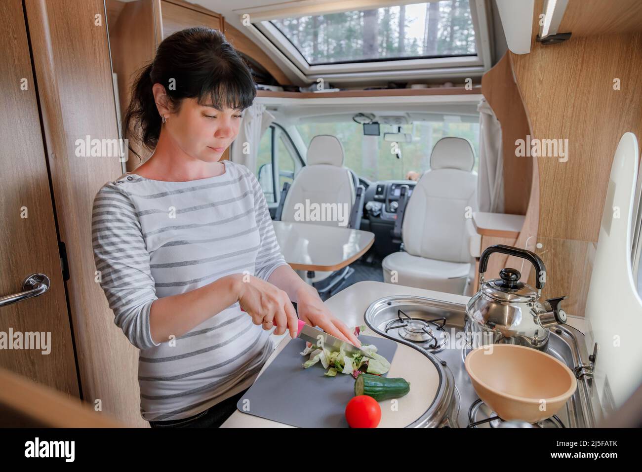 Frau kochen in Reisemobil, Wohnmobil RV Interieur. Familie Urlaub Reisen, Urlaub im Reisemobil, Caravan Auto Urlaub. Stockfoto