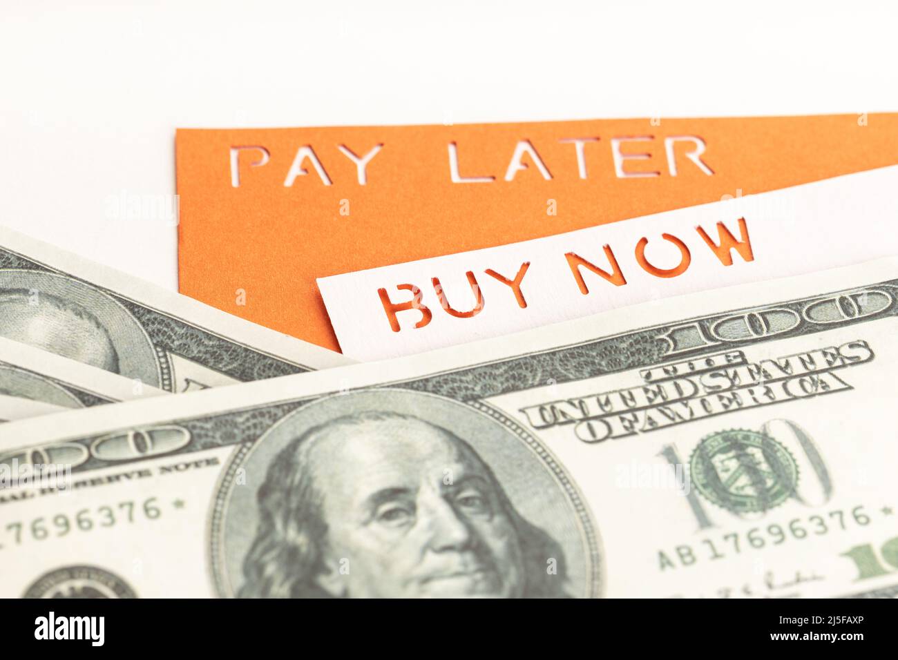 BNPL oder Buy Now Pay Later Concept. Dollarscheine und Etikett mit Botschaft auf weißem Tisch Stockfoto