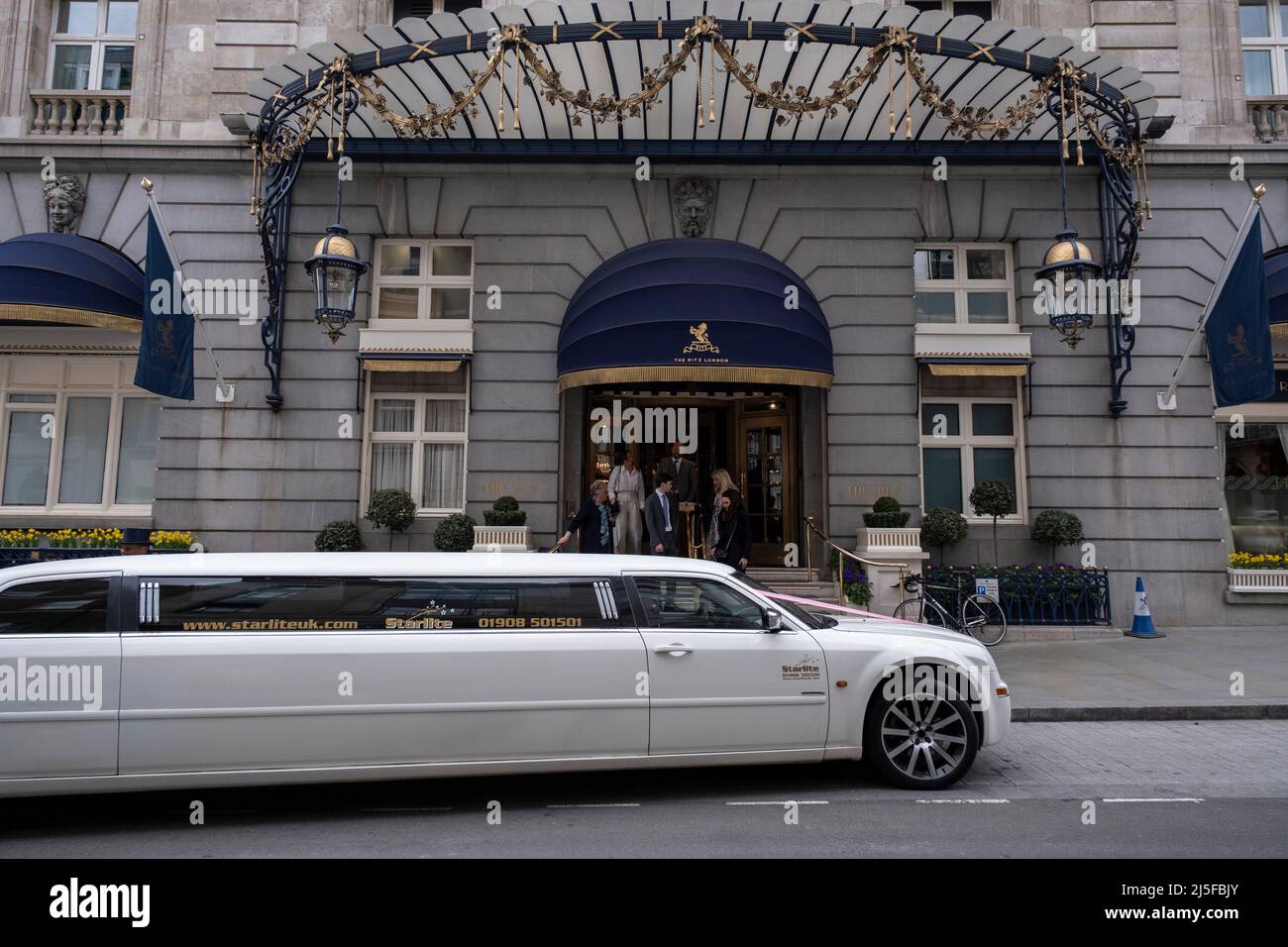 Weiße Stretch-Limousine vor dem Ritz Hotel am 13.. April 2022 in London, Großbritannien. Das Ritz London ist ein denkmalgeschütztes 5-Sterne-Hotel in Piccadilly und ein Symbol für hohe Gesellschaft und Luxus. Es ist eines der renommiertesten und bekanntesten Hotels der Welt. Stockfoto