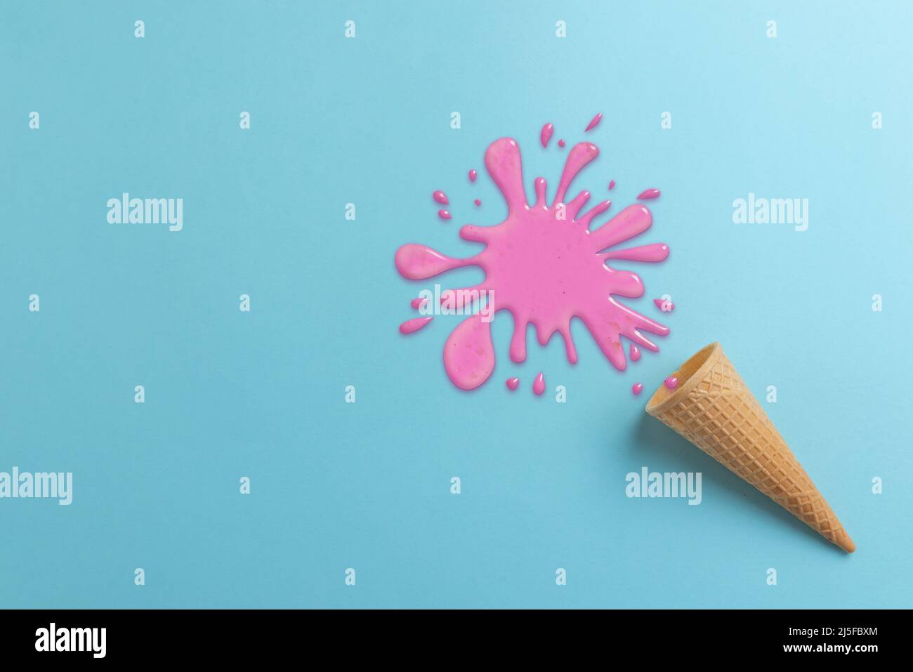 Fallengelassene Eiscreme auf Cyan Oberfläche Konzept. Verschüttete rosafarbene Creme. Draufsicht, flache Lay-Komposition Stockfoto