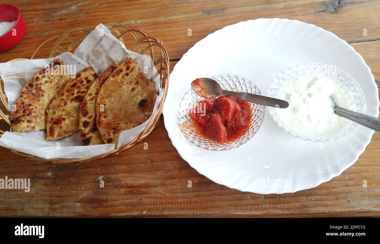 Aaloo (Kartoffel) Paratha ein indisches Frühstück mit Quark und Gurke Stockfoto