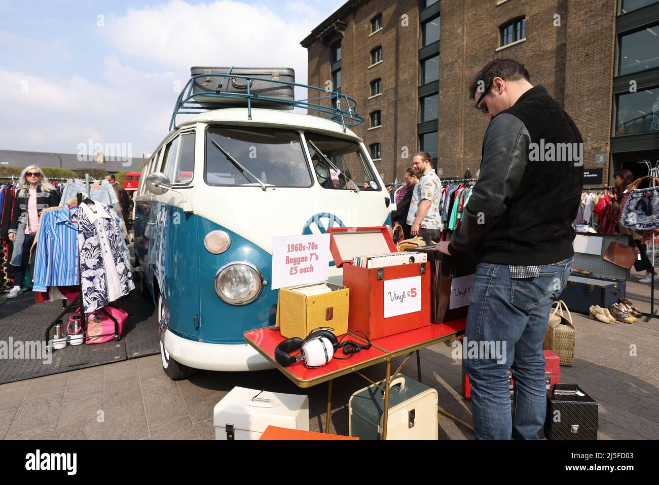 Während des Classic Car Boot Sale in Granary Square, London, durchstöbert ein Mann Schallplatten vor einem VW Campervan aus dem Jahr 1965. Die Veranstaltung wurde in einen Autostiefel-Verkauf umgewandelt, bei dem klassische Fahrzeuge neben Ständen geparkt wurden, an denen alte, recycelte und vorgeliebte Kleidung, Platten, Bric-a-brac und mehr verkauft werden. Bilddatum: Samstag, 23. April 2022. Stockfoto