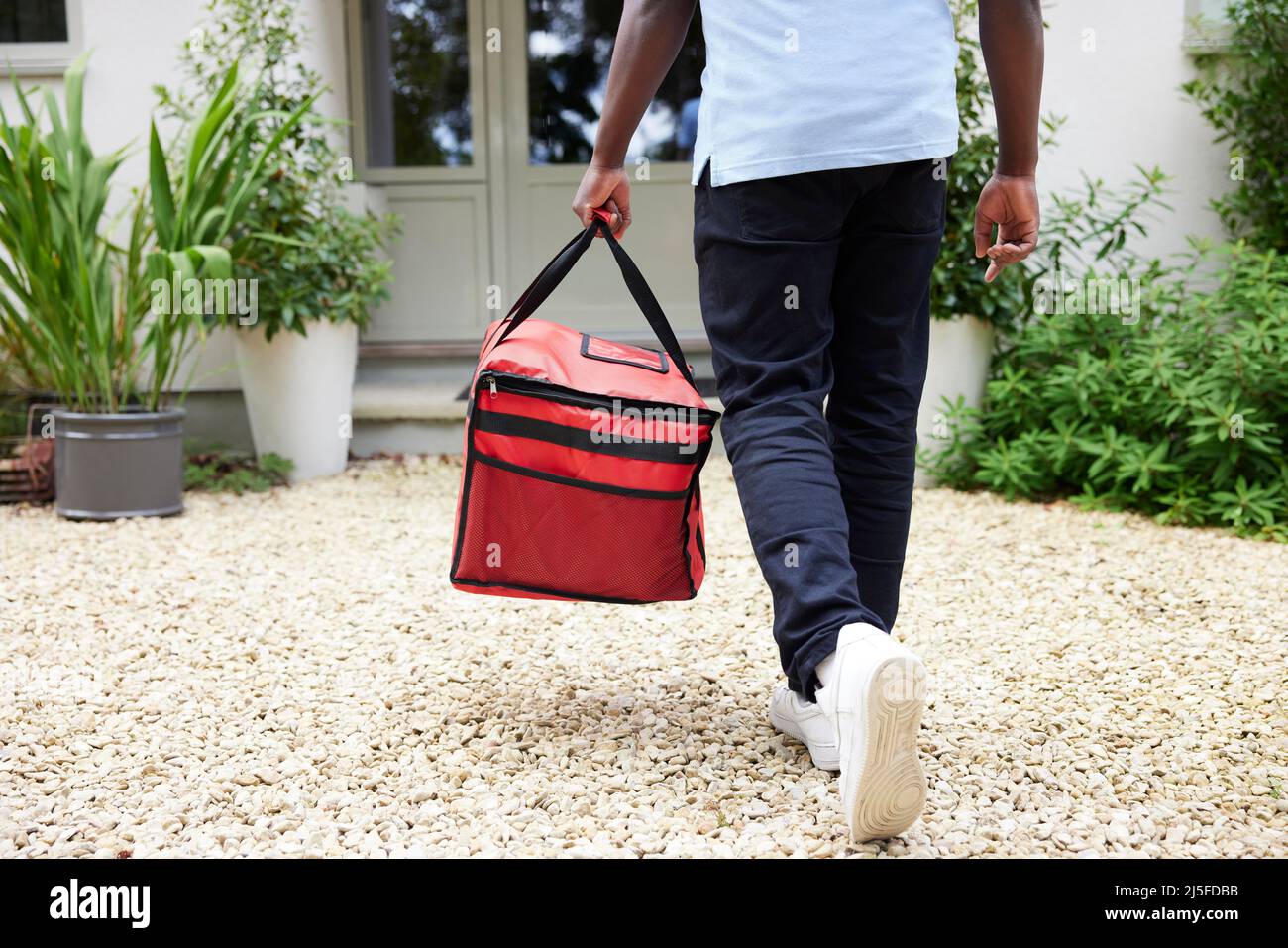 Nahaufnahme Der Rückansicht Des Gig Economy-Fahrers, Der Die Bestellung Von Lebensmitteln Im Online-Takeaway An Das Haus Liefert Stockfoto