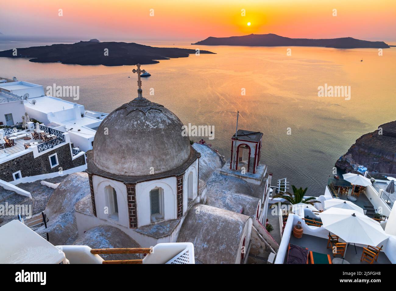 Santorini, Griechenland. Idyllischer Sonnenuntergang mit der alten griechischen Kirche Firostefani und Caldera. Ägäis, Griechische Inseln. Stockfoto