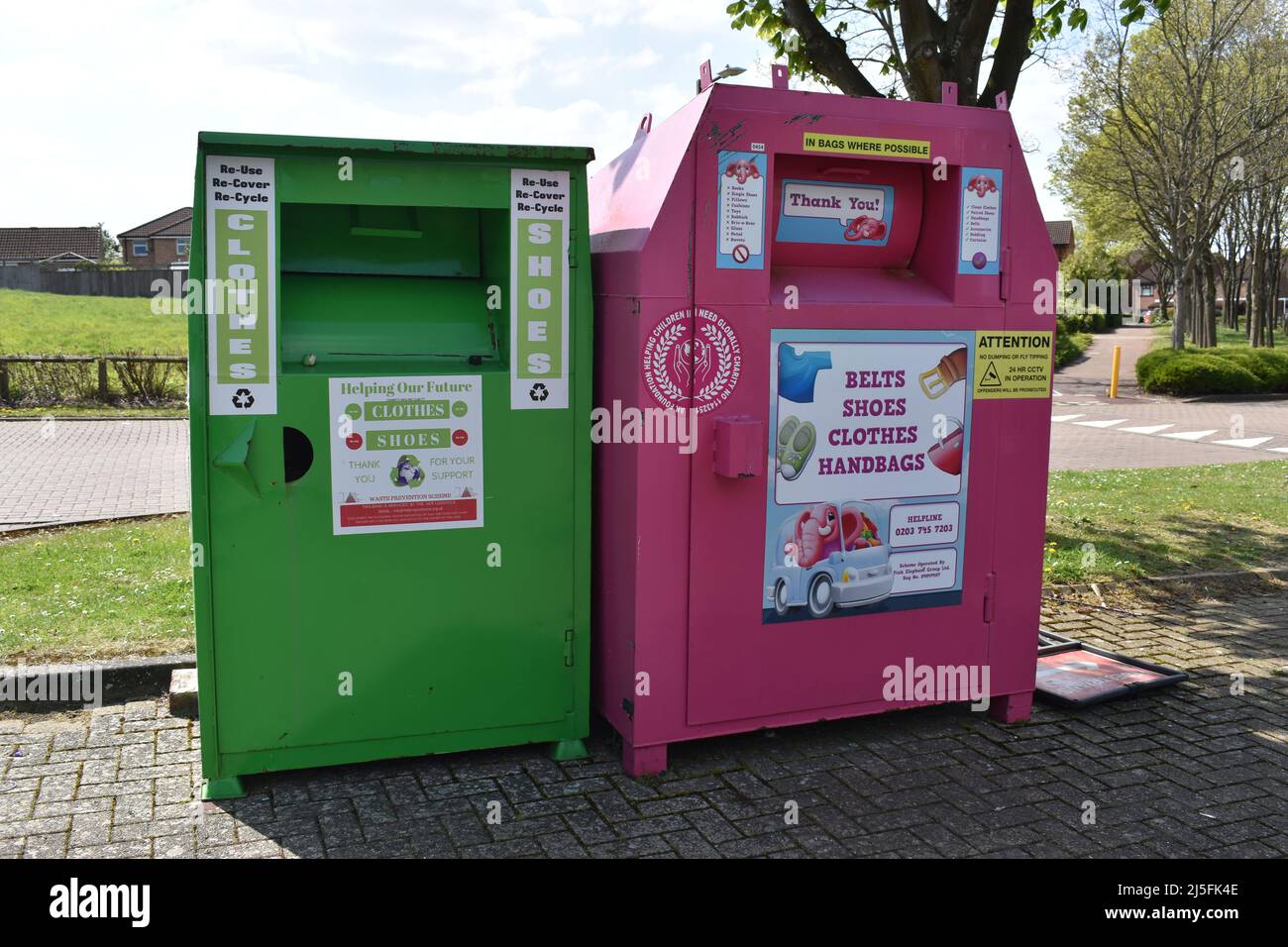 Eine grüne und eine rosa Recycling-Bank für Kleidung und Schuhe. Stockfoto