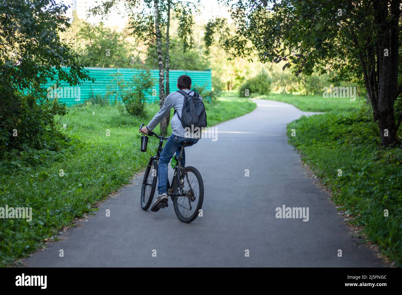 Radfahrer auf einem Spaziergang. Der Typ fährt mit dem Fahrrad die Straße hinunter. Gehen Sie aus der Stadt. Transport auf zwei Rädern. Stockfoto