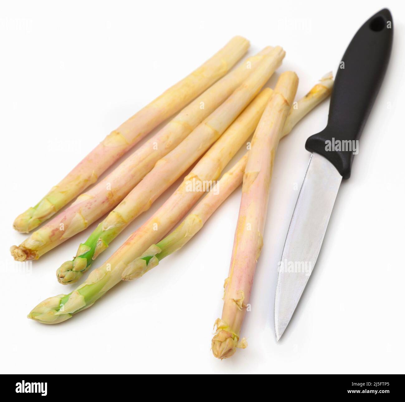 Deutscher weißer Spargel mit einem Messer über Weiß Stockfoto