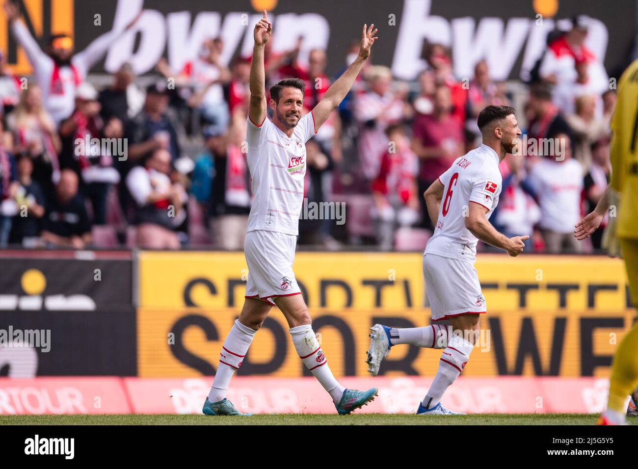 Köln, Deutschland. 23. April 2022. Fußball: Bundesliga, 1. FC Köln - Arminia Bielefeld, Matchday 31, RheinEnergieStadion. Kölner Torschütze Mark Uth feiert nach seinem Tor um 1:0 Uhr. Salih Özcan verläuft auf der rechten Seite. Quelle: Marius Becker/dpa - WICHTIGER HINWEIS: Gemäß den Anforderungen der DFL Deutsche Fußball Liga und des DFB Deutscher Fußball-Bund ist es untersagt, im Stadion und/oder vom Spiel aufgenommene Fotos in Form von Sequenzbildern und/oder videoähnlichen Fotoserien zu verwenden oder zu verwenden./dpa/Alamy Live News Stockfoto