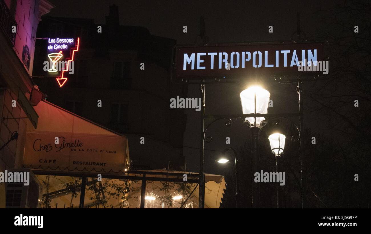 Paris, Frankreich: Nachtansicht, Straßenlaternen und Neonschilder am Eingang der Montmartre Metrostation, berühmter Hügel im nördlichen 18. Arrondissement Stockfoto