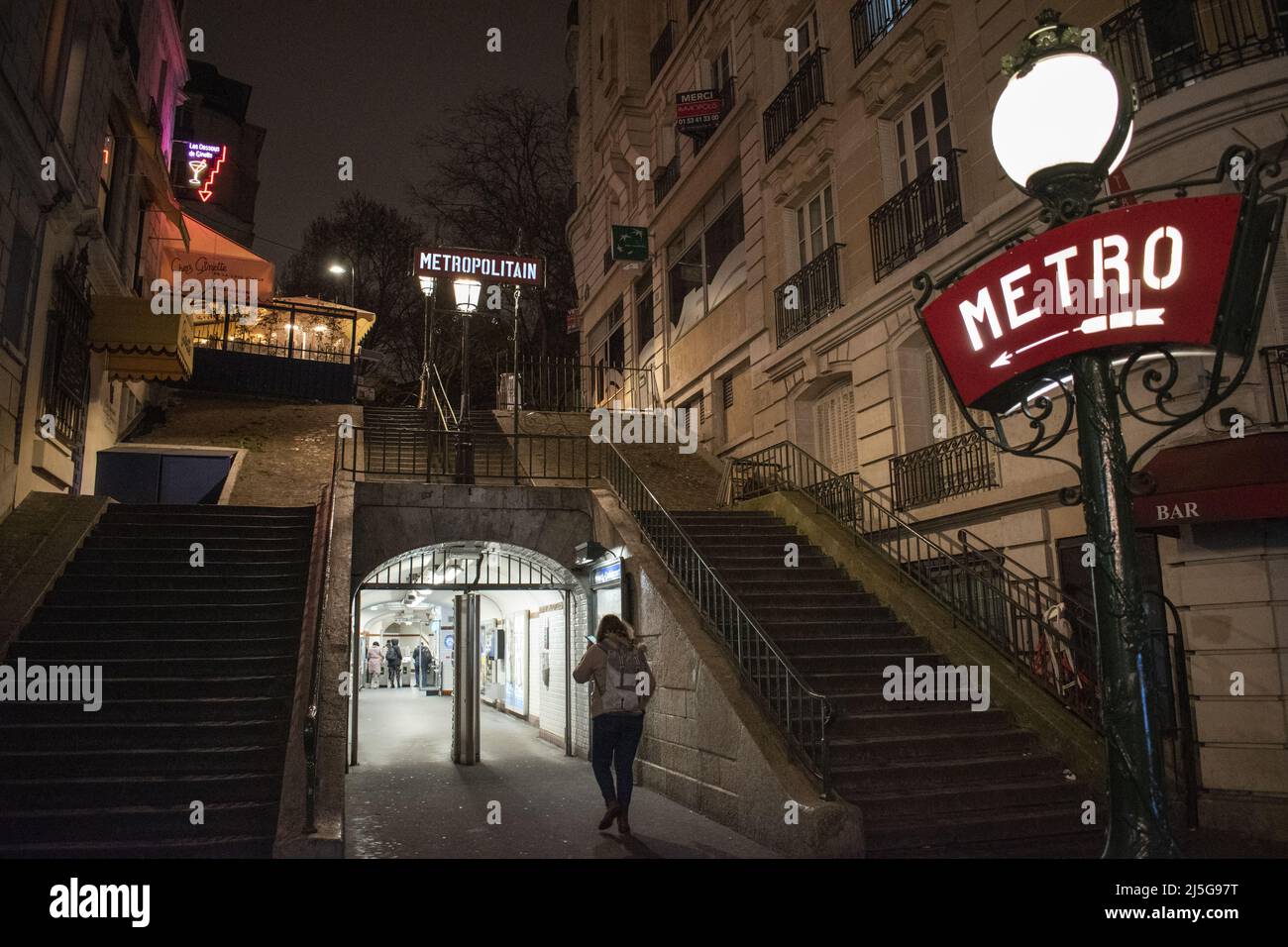 Paris, Frankreich: Nachtansicht, Straßenlaternen und Neonschilder am Eingang der Montmartre Metrostation, berühmter Hügel im nördlichen 18. Arrondissement Stockfoto