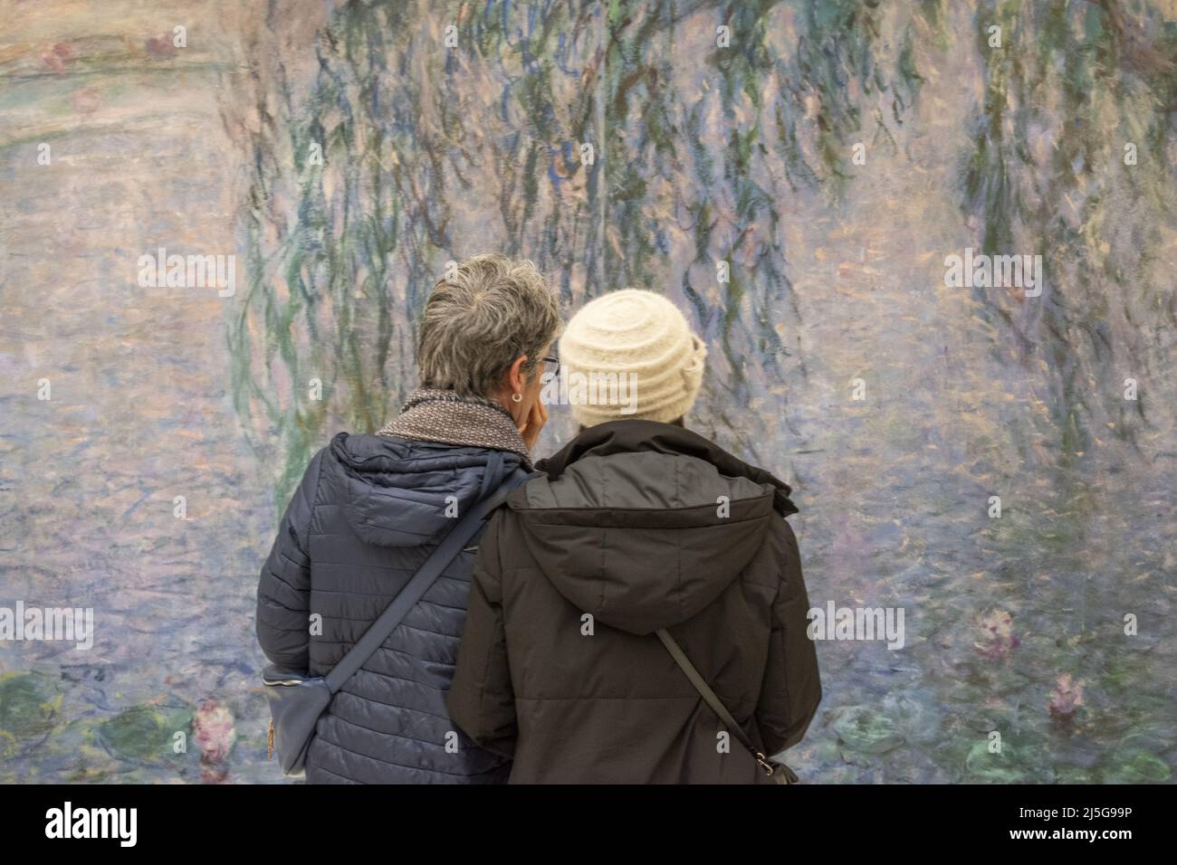 Paris, Frankreich, Europa: Besucher vor den Nympheas (Seerosen), einer berühmten Serie von dekorativen Tafeln von Claude Monet im Musée de l'Orangerie Stockfoto