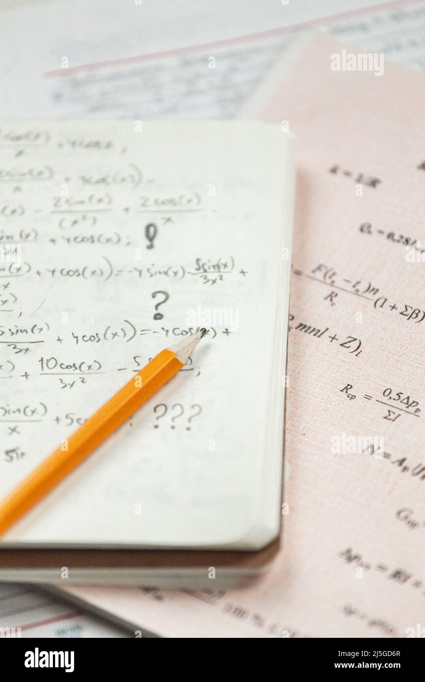 Mathematische Formeln sind in Bleistift auf ein Stück Papier geschrieben, mathematische Probleme Stockfoto