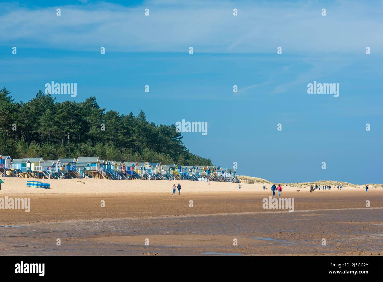 Menschen, die am Strand spazieren, Blick auf Menschen, die am Strand von Wells-next-the-Sea an der nördlichen Norfolk-Küste, England, Großbritannien, spazieren gehen Stockfoto