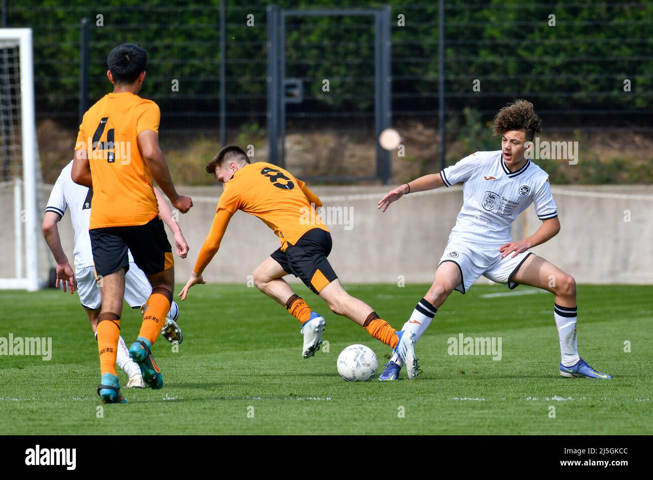 Swansea, Wales. 23. April 2022. #8 Triallist von Hull City unter 18s Jahren wird von Filip Lissah von Swansea City unter 18s Jahren während des Spiels der Professional Development League zwischen Swansea City unter 18 und Hull City unter 18 Jahren an der Swansea City Academy in Swansea, Wales, Großbritannien, am 23. April 2022 angegangen. Quelle: Duncan Thomas/Majestic Media/Alamy Live News. Stockfoto