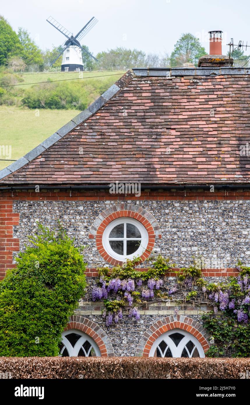 Dach eines charaktervollen Häuschens im Dorf Turville in den Chilterns, mit Cobstone Mill an der Spitze des Hügels dahinter. Stockfoto