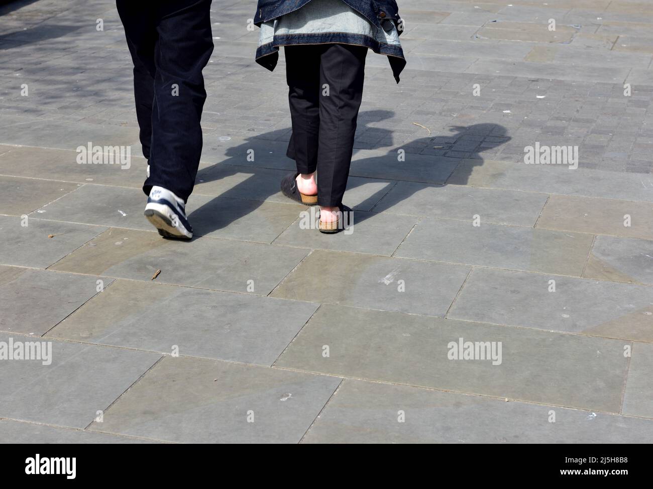 Beine von zwei Personen, die weggehen Stockfoto