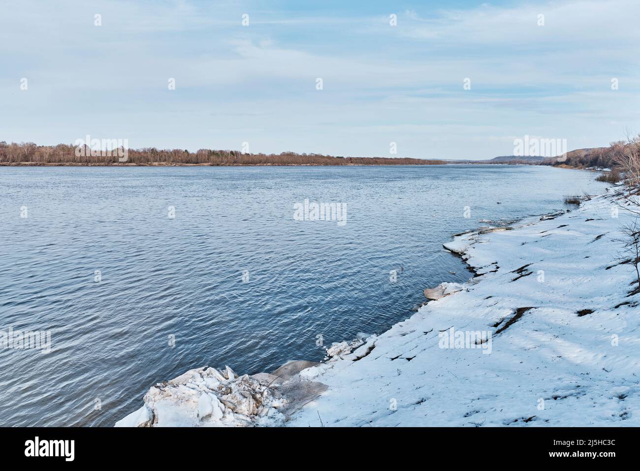 Frühlingslandschaft am Fluss, Russland. Geschmolzener Schnee und graue Eisstücke an der Küste. Stockfoto