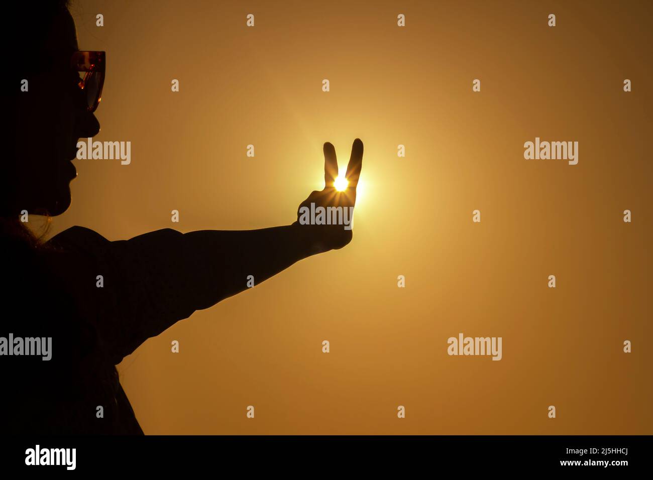 Siegeszeichen mit menschlicher Hand Foto Konzept Idee futuristischer Cyberpunk Neon Sonne Stockfoto