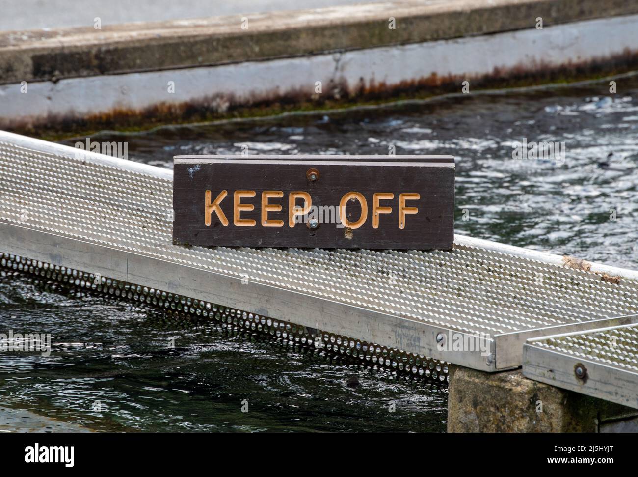 Keep off-Schild sagt der Öffentlichkeit, nicht auf diese Gehwege über das Wasser zu bekommen. Bokeh Stockfoto