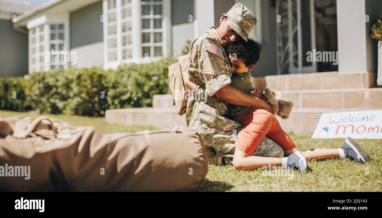 Mama vom Militär willkommen geheißen. Entzückender kleiner Junge umarmt seine Mutter auf ihrer Heimkehr. Militärische Mutter, die ein emotionales Wiedersehen mit ihrem Sohn a Stockfoto