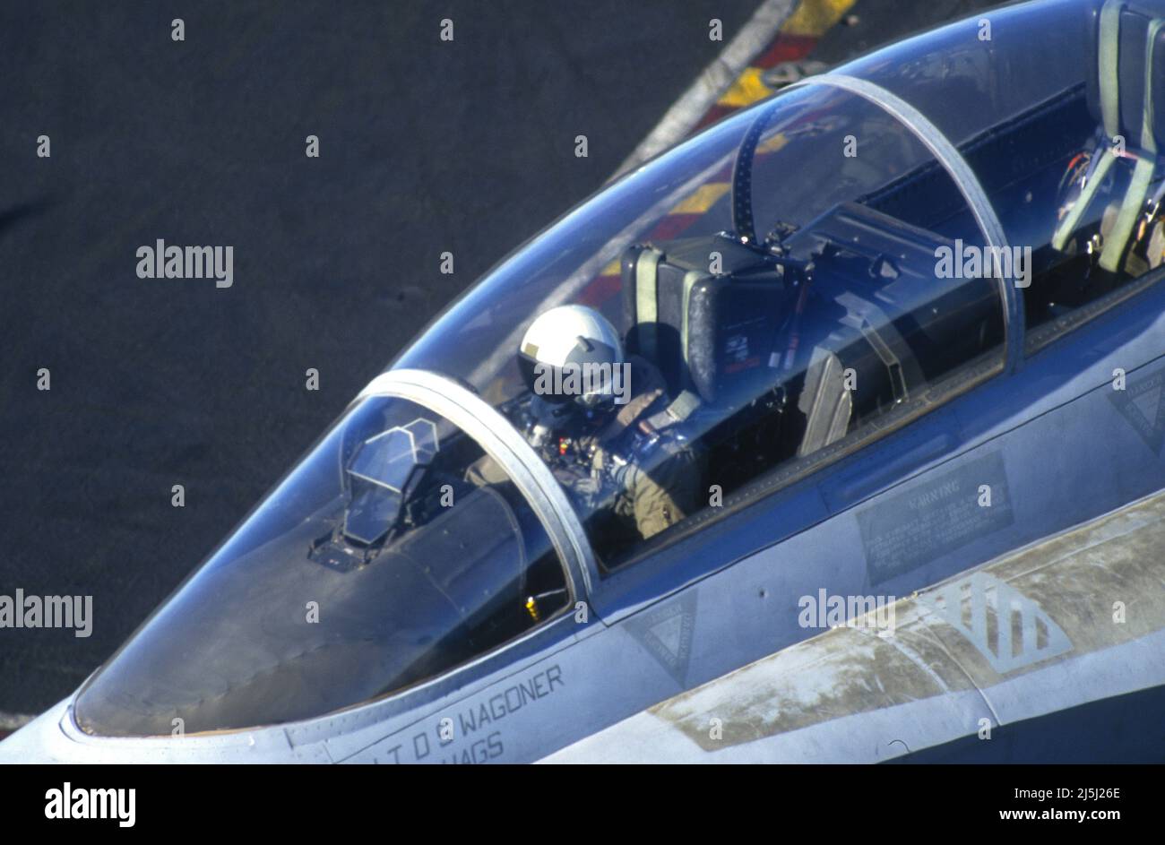 Der Pilot eines F/A-18D manövriert Flugzeuge an Deck eines Flugzeugträgers Stockfoto