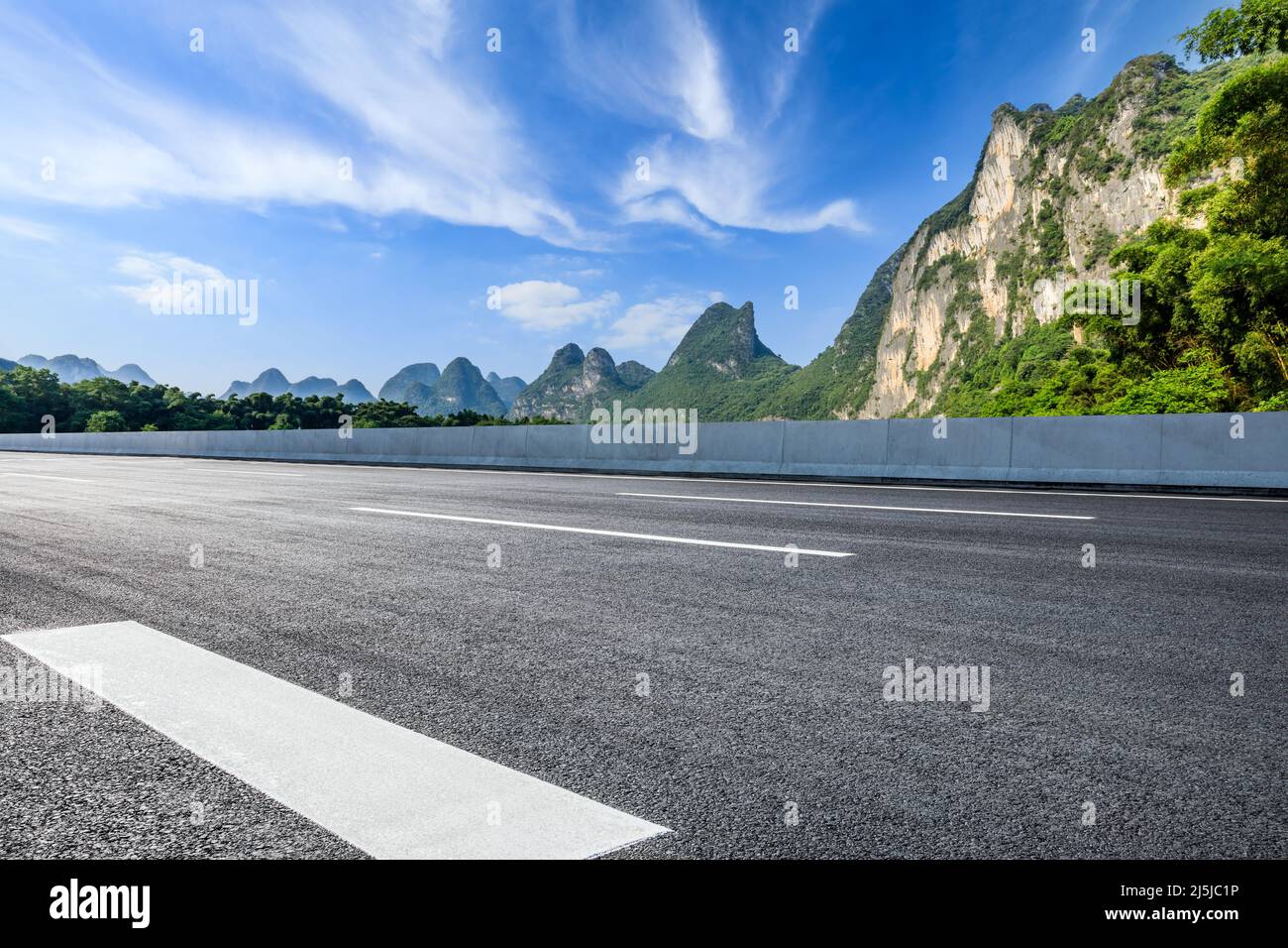 Asphaltstraße und Berglandschaft unter blauem Himmel im Sommer Stockfoto