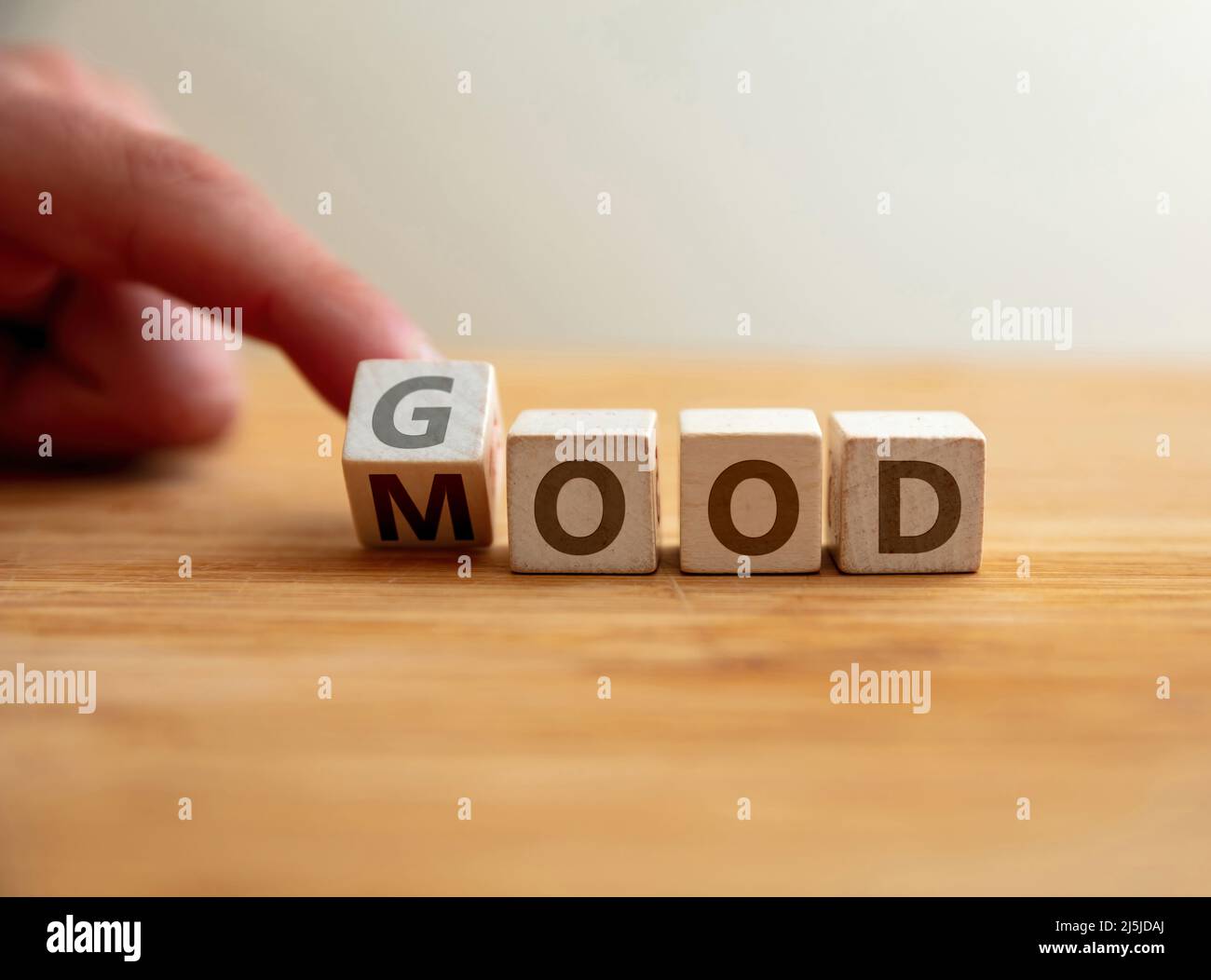 Gute Laune haben Konzept. Hand dreht Buchstaben auf Holzwürfel und ändert das Wort Stimmung zu gut. Botschaft für Selbstversorgung, positive Energie, Spaß, Glück. Stockfoto