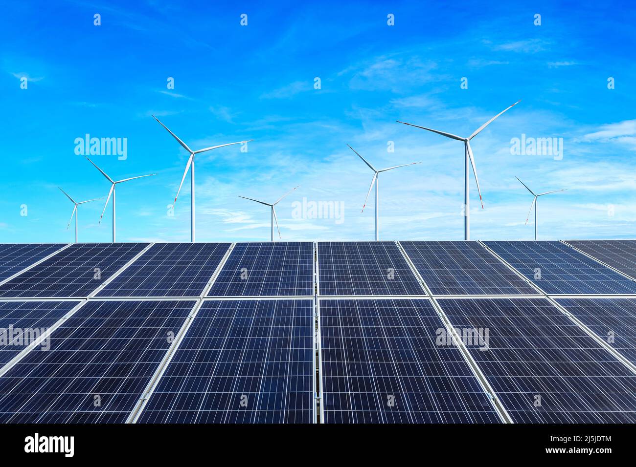 Sonnenkollektoren und Windkraftanlagen Landschaft unter blauem Himmel. Konzept für grüne Energie. Stockfoto