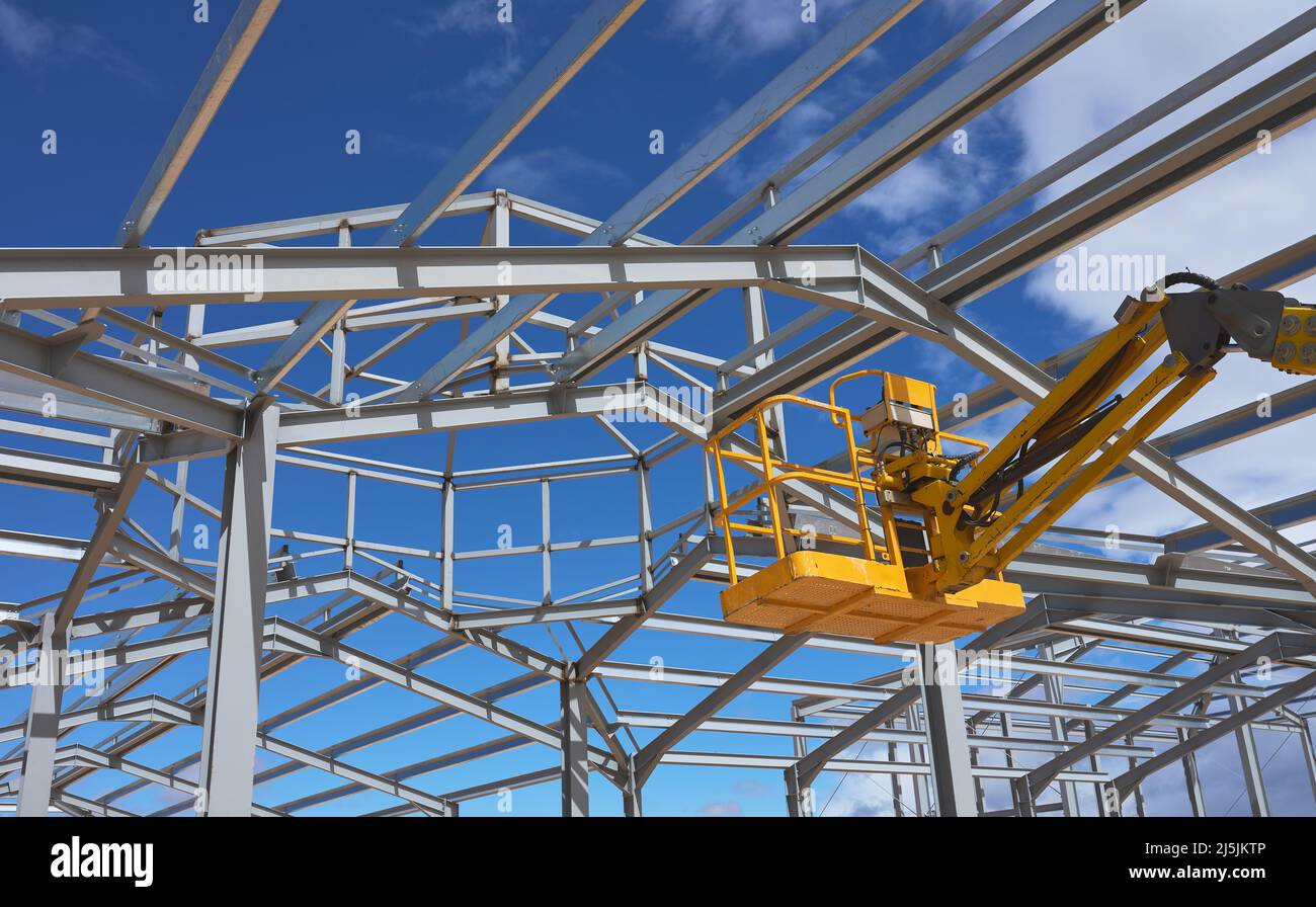 Detail einer gelben Hebebühne für den Bau einer Metallkonstruktion Stockfoto