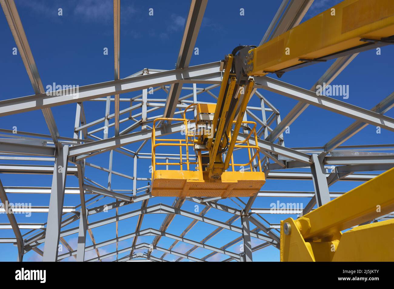Detail einer gelben Hebebühne für den Bau einer Metallkonstruktion Stockfoto