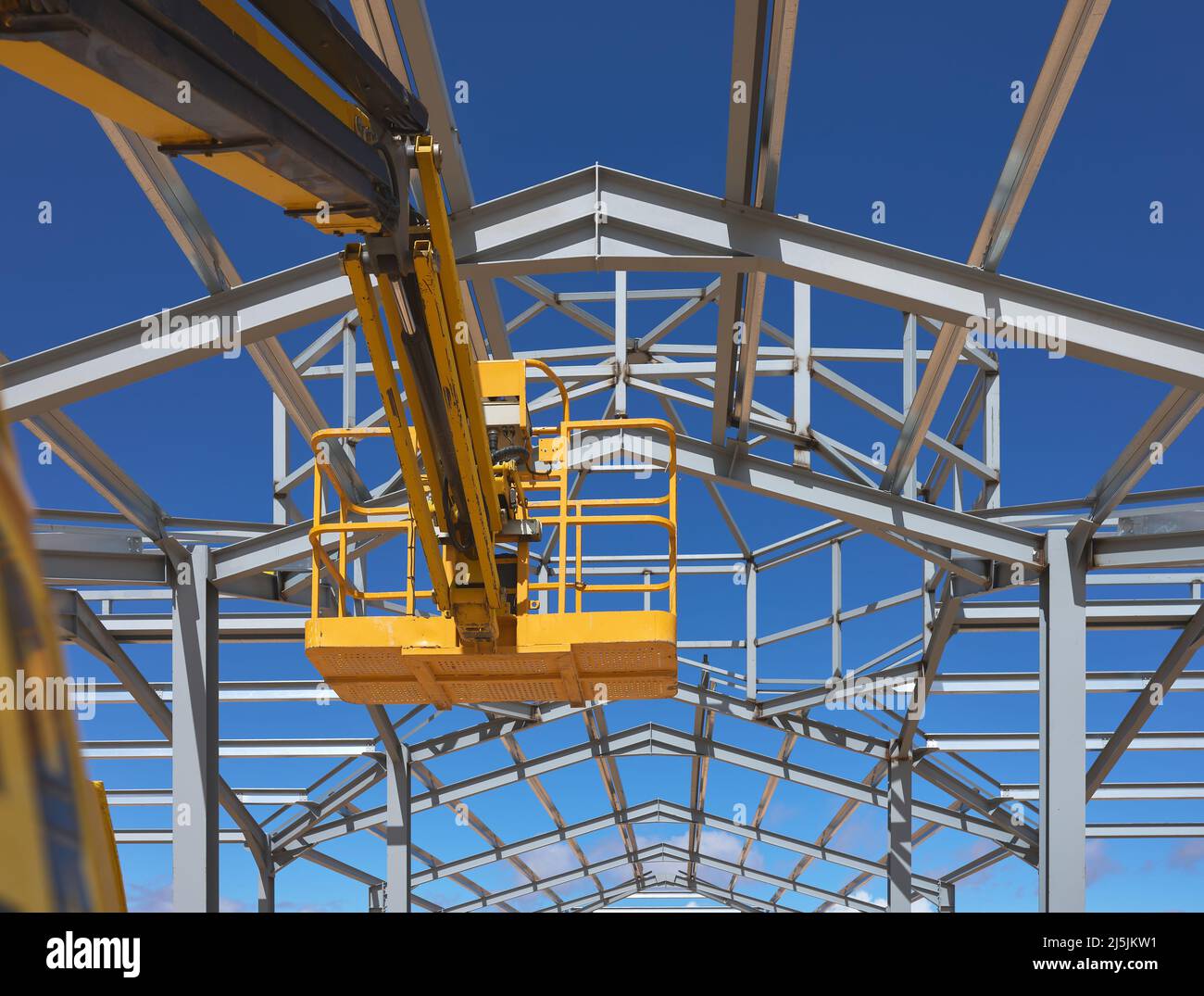 Detail einer gelben Hebebühne für den Bau einer Metallkonstruktion Stockfoto