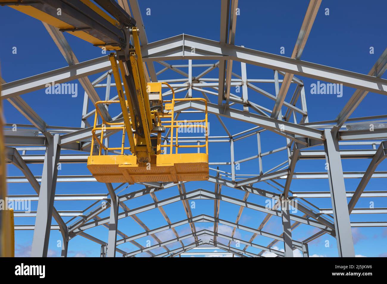 Detail einer gelben Hebebühne für den Bau einer Metallkonstruktion Stockfoto