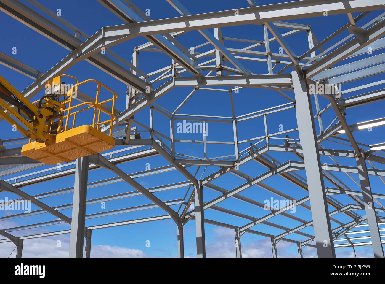Detail einer gelben Hebebühne für den Bau einer Metallkonstruktion Stockfoto