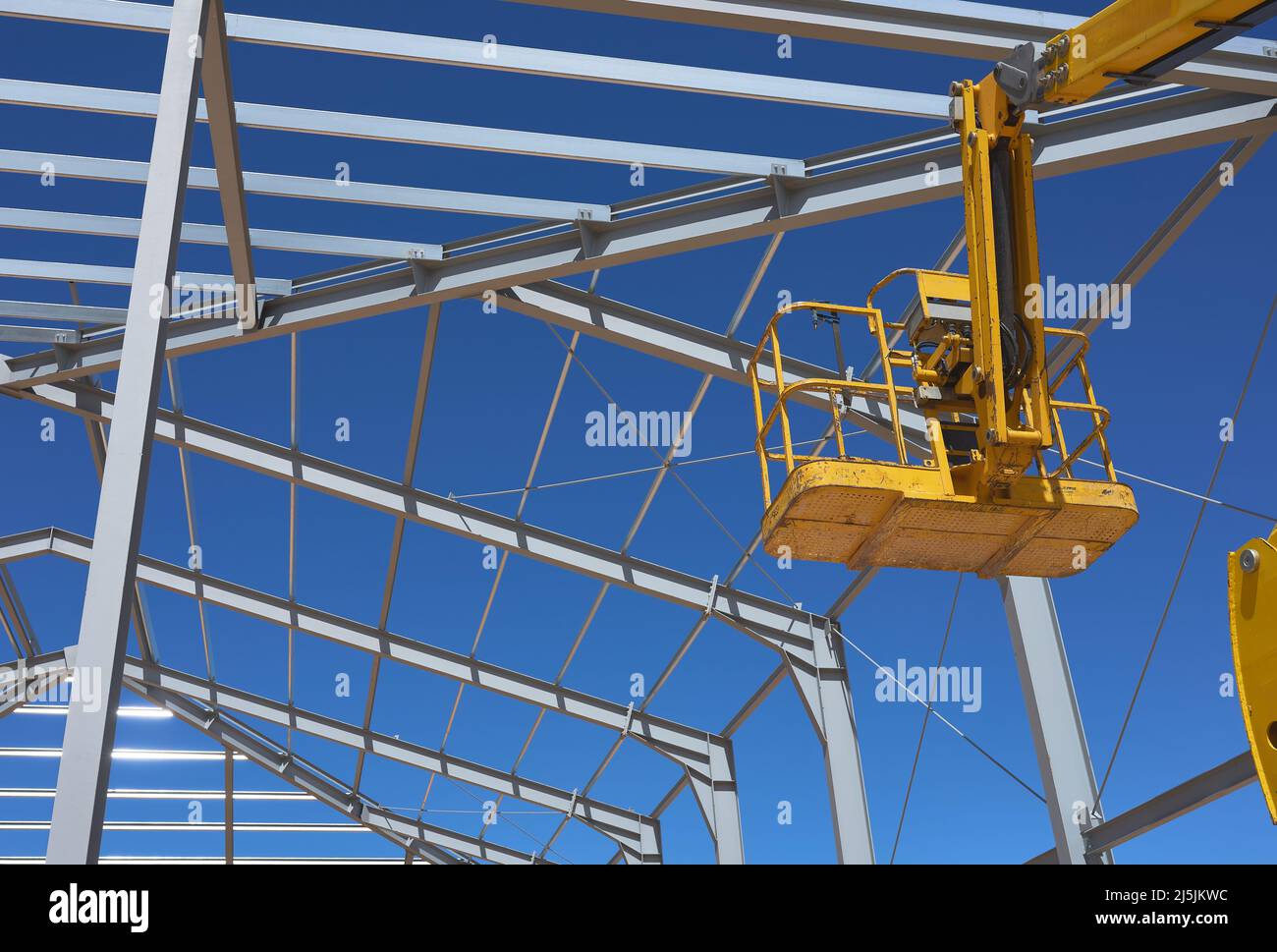Detail einer gelben Hebebühne für den Bau einer Metallkonstruktion Stockfoto
