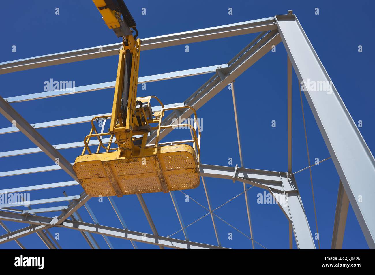 Detail einer gelben Hebebühne für den Bau einer Metallkonstruktion Stockfoto