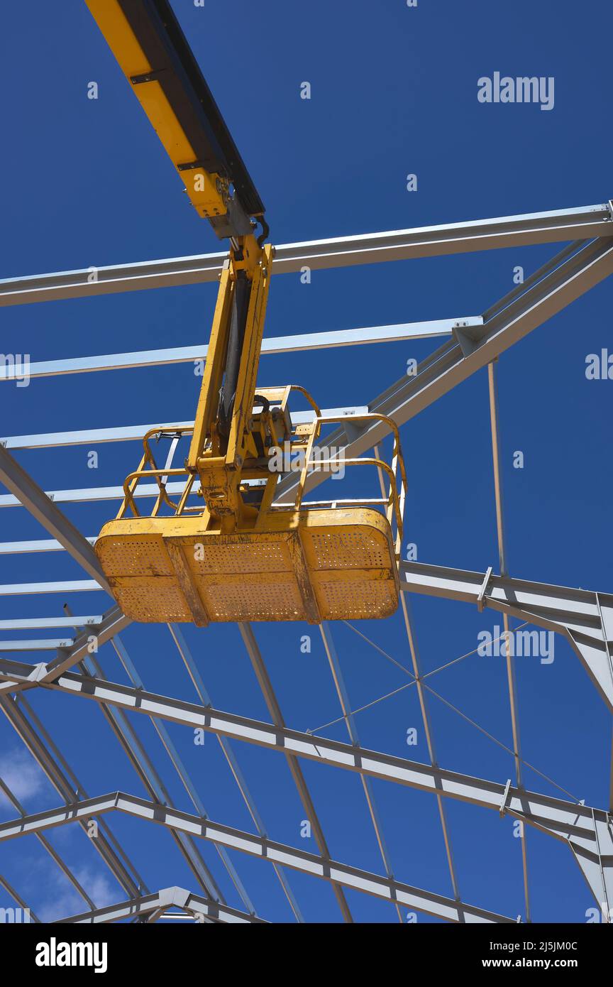 Detail einer gelben Hebebühne für den Bau einer Metallkonstruktion Stockfoto