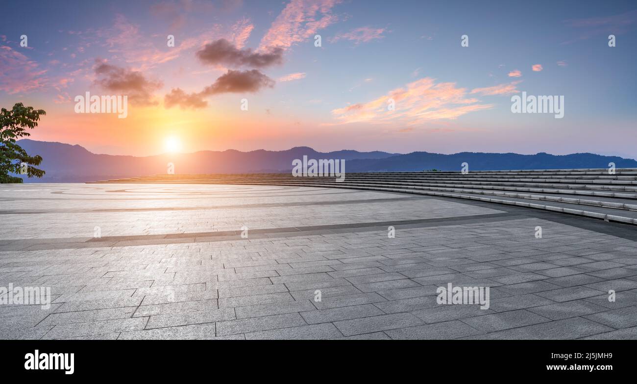 Leerer quadratischer Boden und Berg mit Himmelswolkenlandschaft bei Sonnenuntergang Stockfoto