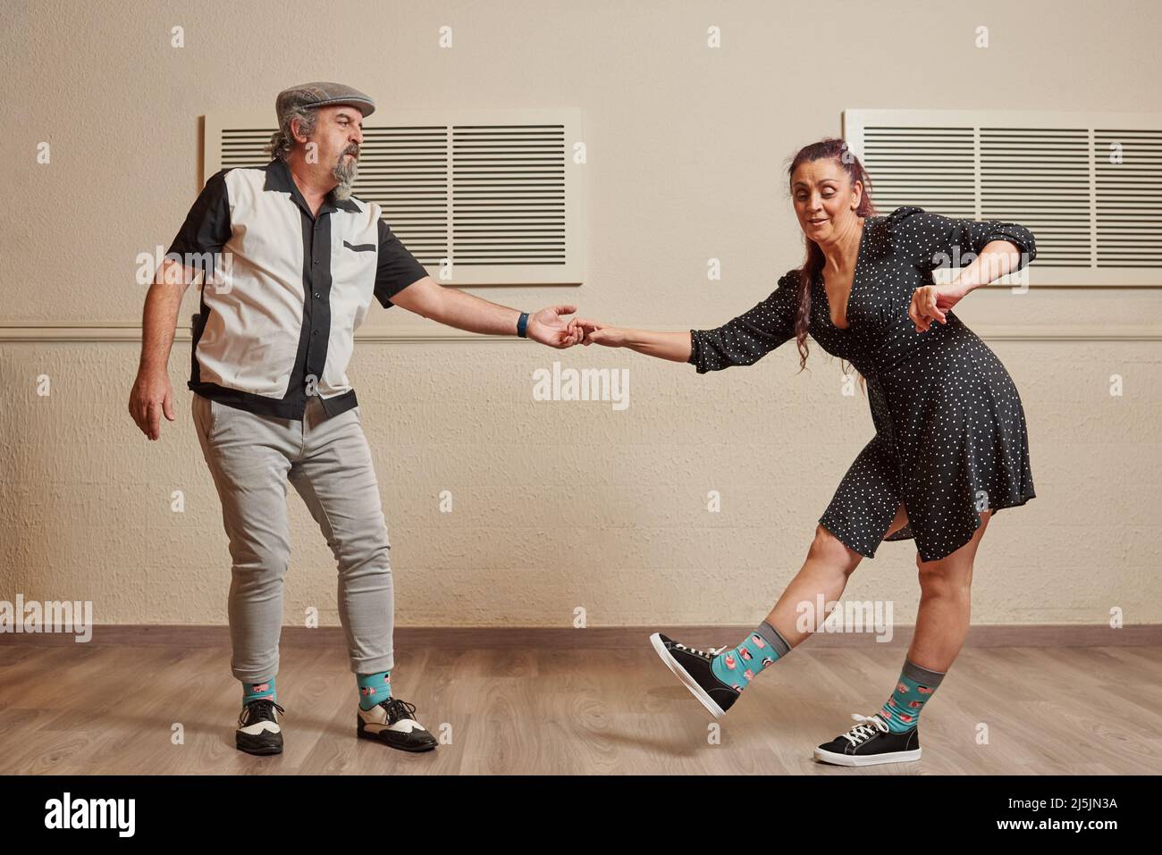 Ein Paar mit älteren Erwachsenen, das lindy Hop in einem Ballsaal tanzt Stockfoto