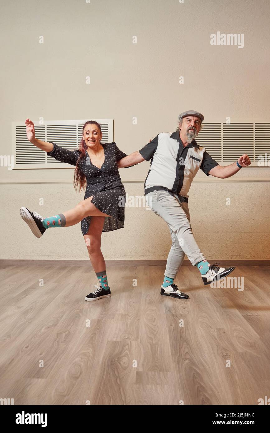 Ein Paar mit älteren Erwachsenen, das lindy Hop in einem Ballsaal tanzt Stockfoto