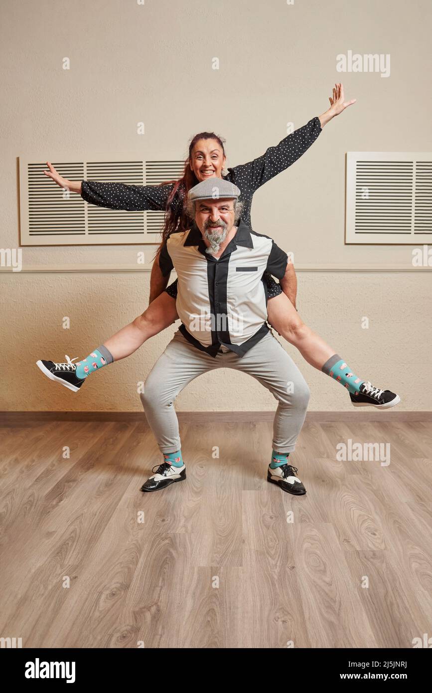 Ein Paar mit älteren Erwachsenen, das lindy Hop in einem Ballsaal tanzt Stockfoto