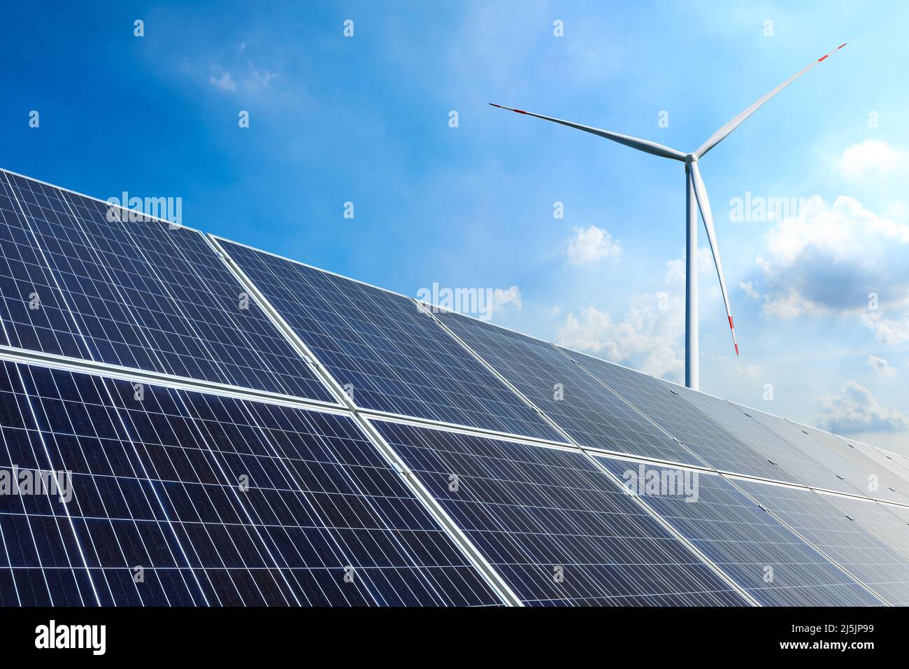 Sonnenkollektoren und Windkraftanlagen Landschaft unter blauem Himmel. Konzept für grüne Energie. Stockfoto