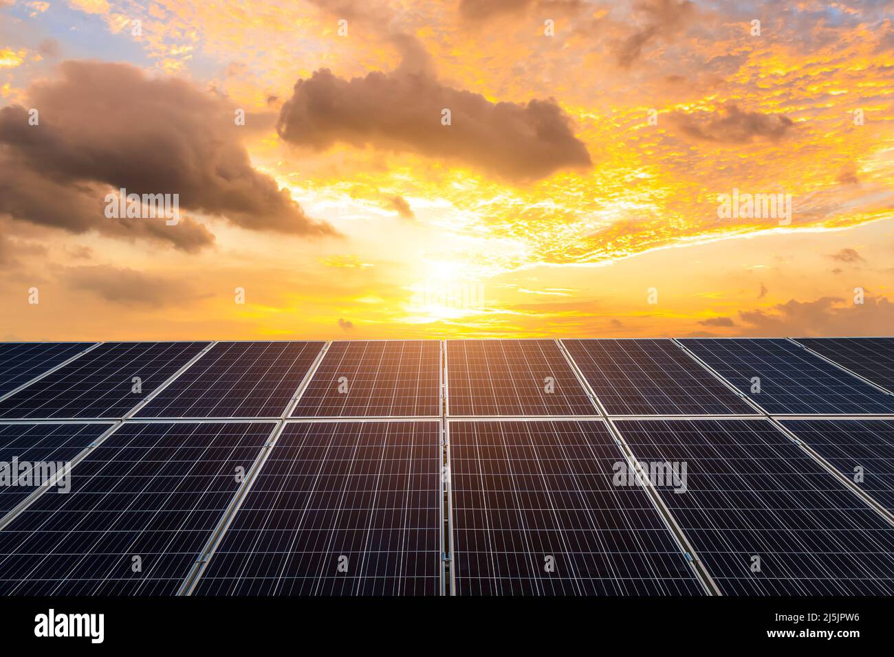 Photovoltaik-Kraftwerk bei schönem Sonnenaufgang. Konzept für grüne Energie. Stockfoto