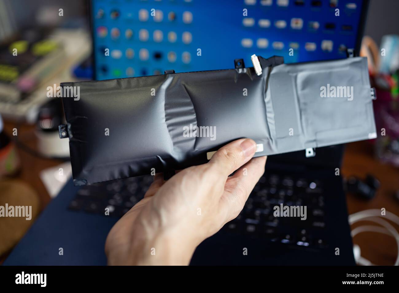 Geschwollener Laptop-Akku in der Hand Stockfoto