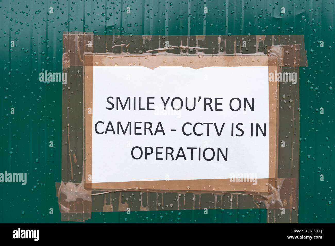 Lächeln Sie sind auf einem CCTV-Schild, das die Öffentlichkeit warnt, dass sie beobachtet und aufgezeichnet werden. Stoppen Sie Kriminalität, Anti-Sozialverhalten, Sicherheitskonzept Stockfoto