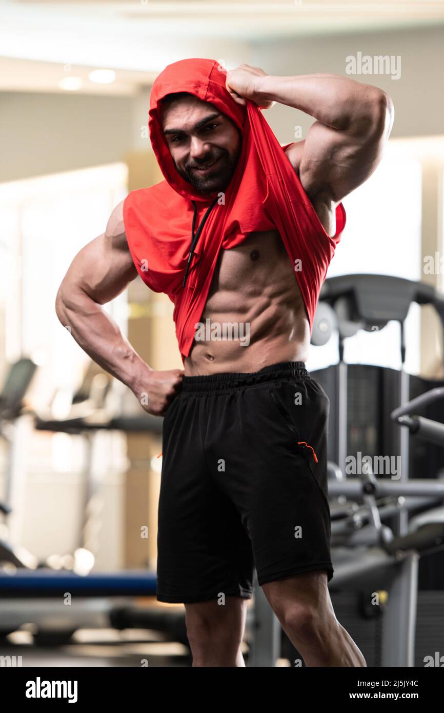 Stark Bodybuilder Gesunder junger Mann, der stark im Fitnessstudio steht und die Muskeln ...