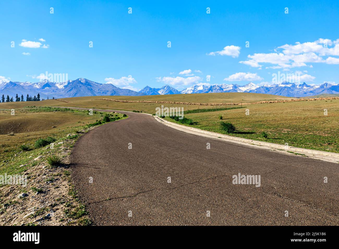 Asphaltstraße und Berg mit schönen Wolken unter blauem Himmel Stockfoto