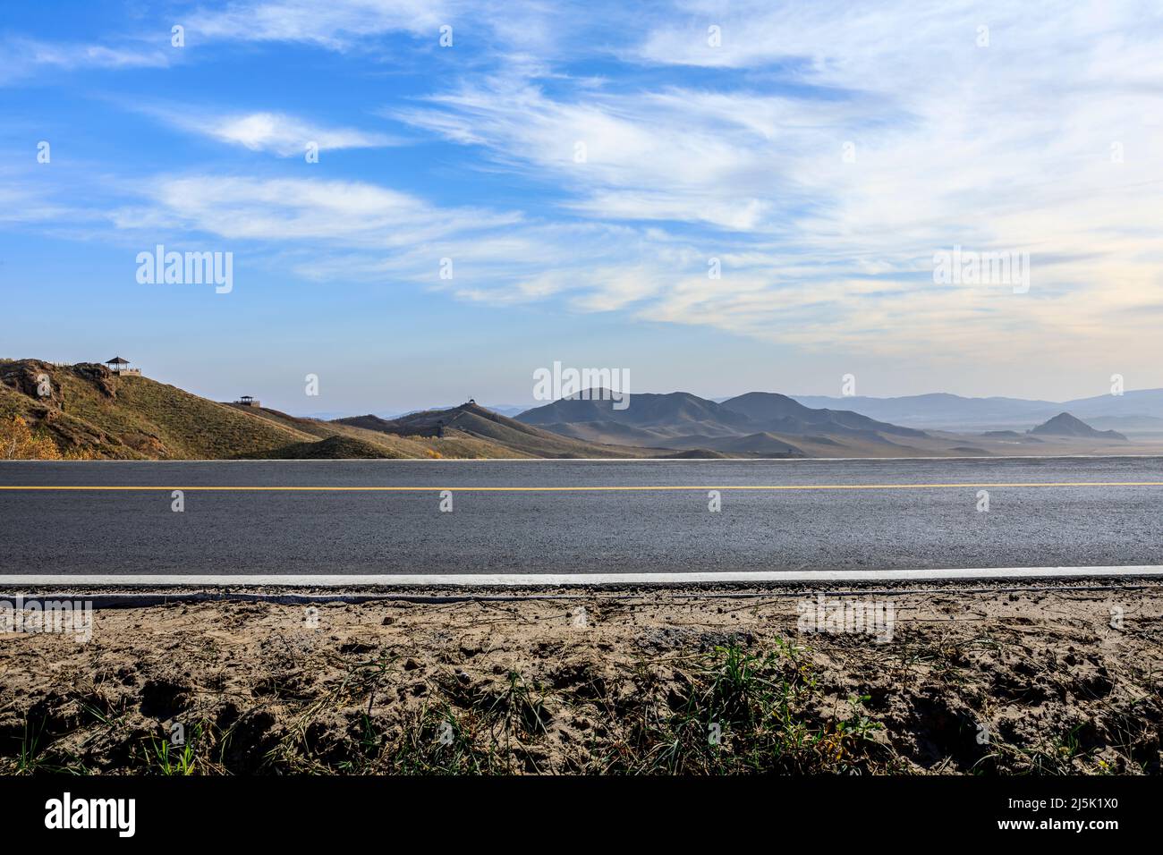Leere Asphaltstraße und Berglandschaft unter blauem Himmel Stockfoto