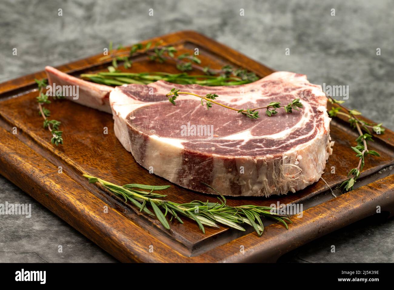 Rohes Kalbshacken auf dunklem Hintergrund. Rohes Kalbshacken auf Holzdielen. Nahaufnahme Stockfoto