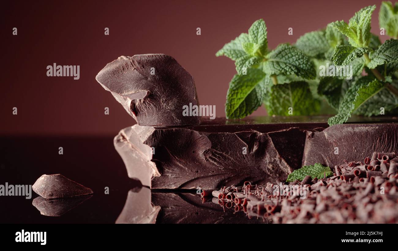 Bitterschokolade mit Minze auf schwarzem reflektierendem Hintergrund. Stockfoto