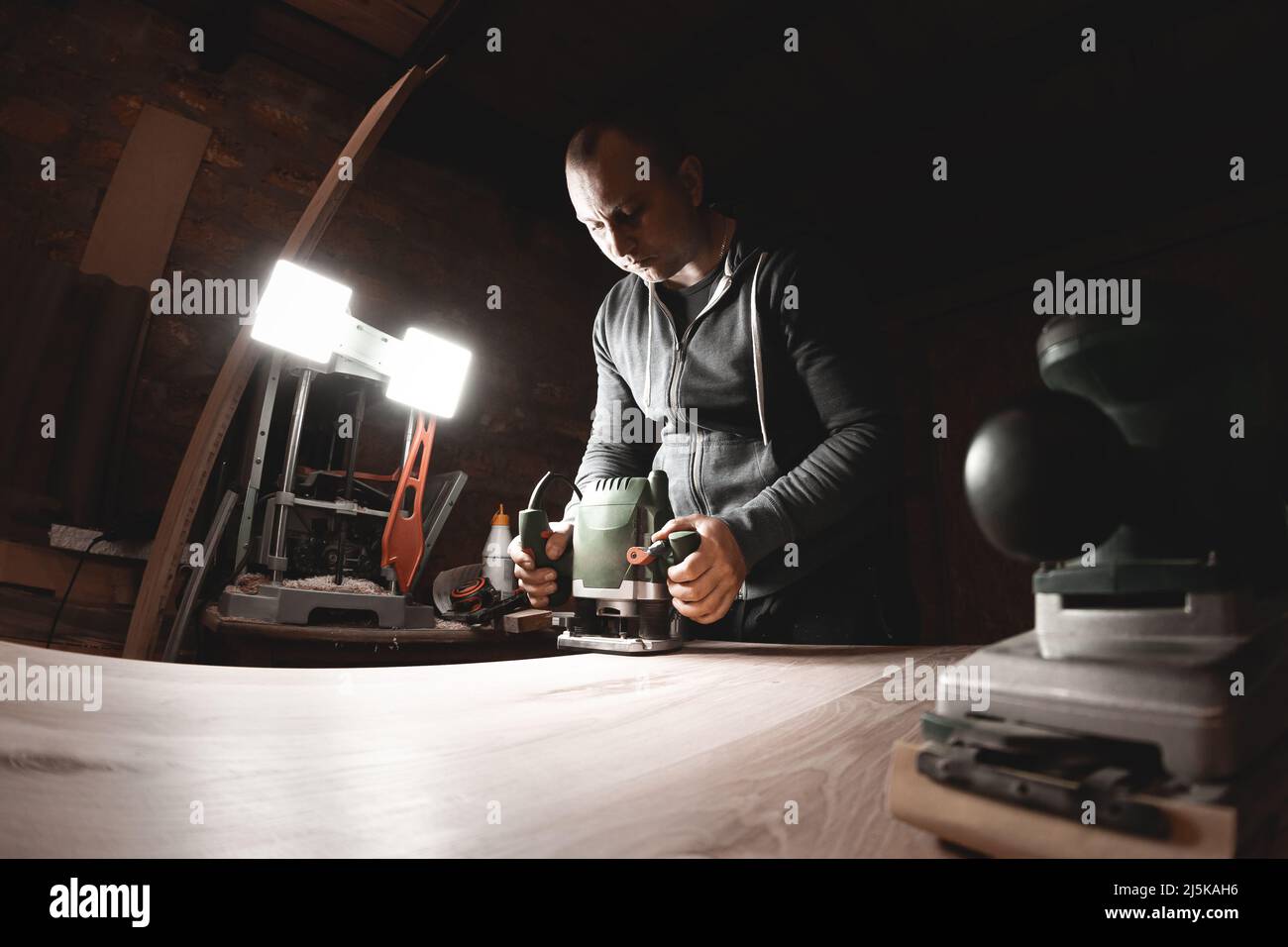 Zimmermann mit elektrischer Handfräsmaschine bei der Arbeit Stockfoto